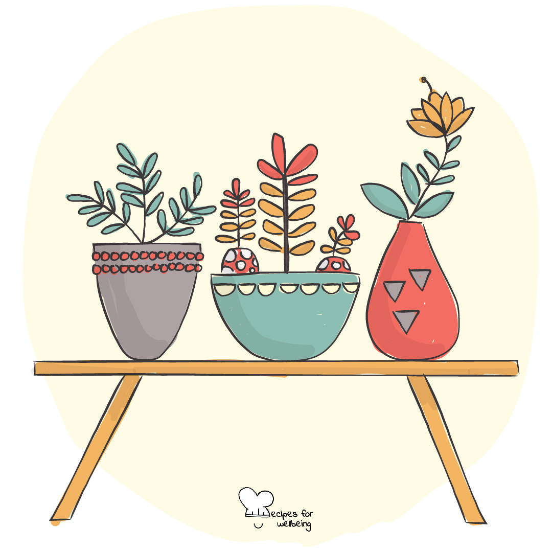 Three potted plants side by side on a wooden table